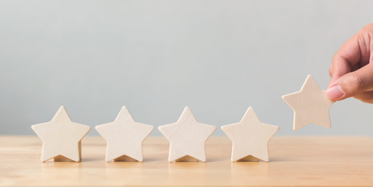 Hand,Putting,Wooden,Five,Star,Shape,On,Table